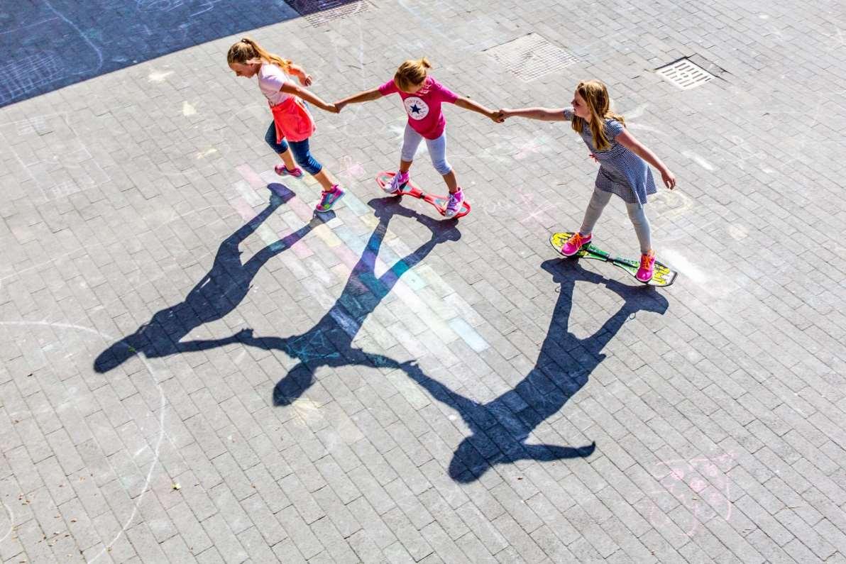Drie kinderen skaten hand in hand op het schoolplein van de Antoniusschool in Kudelstaart. Drie kinderen skaten hand in hand op het schoolplein van de Antoniusschool in Kudelstaart.