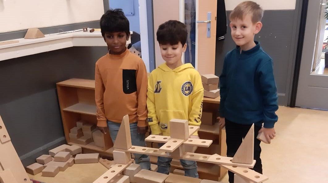 Drie kinderen spelen met blokken in Al Ummah school in Enschede.