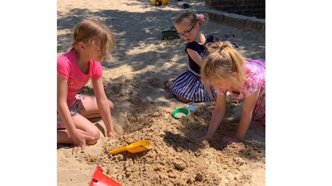 Drie kinderen spelen met zand op het schoolplein van De Wendakker in Oldenzaal. Drie kinderen spelen met zand op het schoolplein van De Wendakker in Oldenzaal.