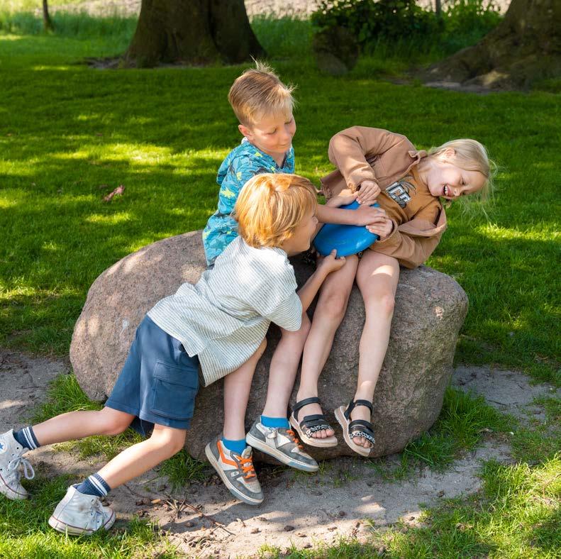 Drie kinderen spelen op een grote steen in het schoolplein van Basisschool Lambertus in Vessem. Drie kinderen spelen op een grote steen in het schoolplein van Basisschool Lambertus in Vessem.