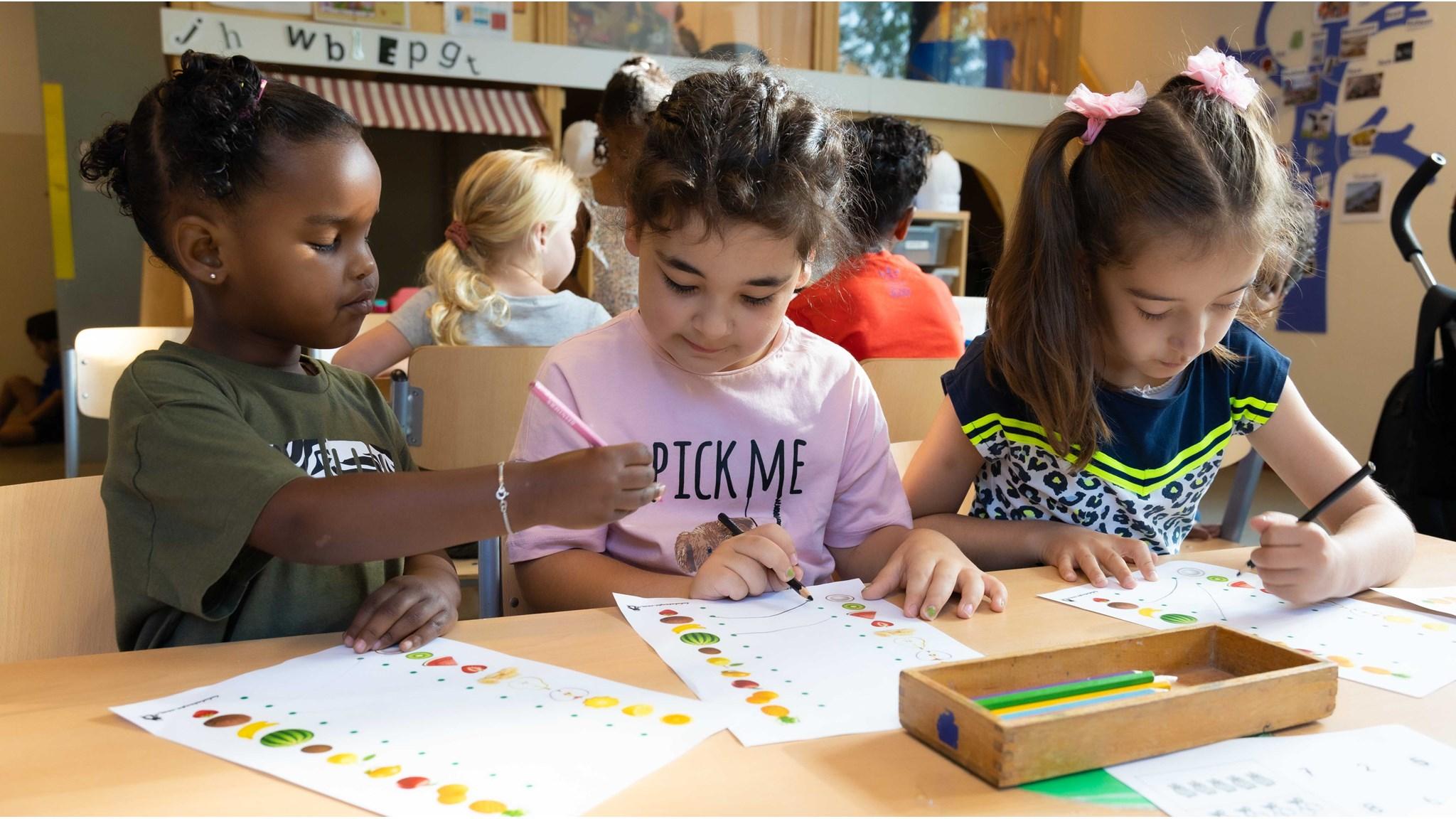 Drie kinderen van Basisschool Baardwijk in Waalwijk zijn bezig met knutselen aan een tafel. Drie kinderen van Basisschool Baardwijk in Waalwijk zijn bezig met knutselen aan een tafel.