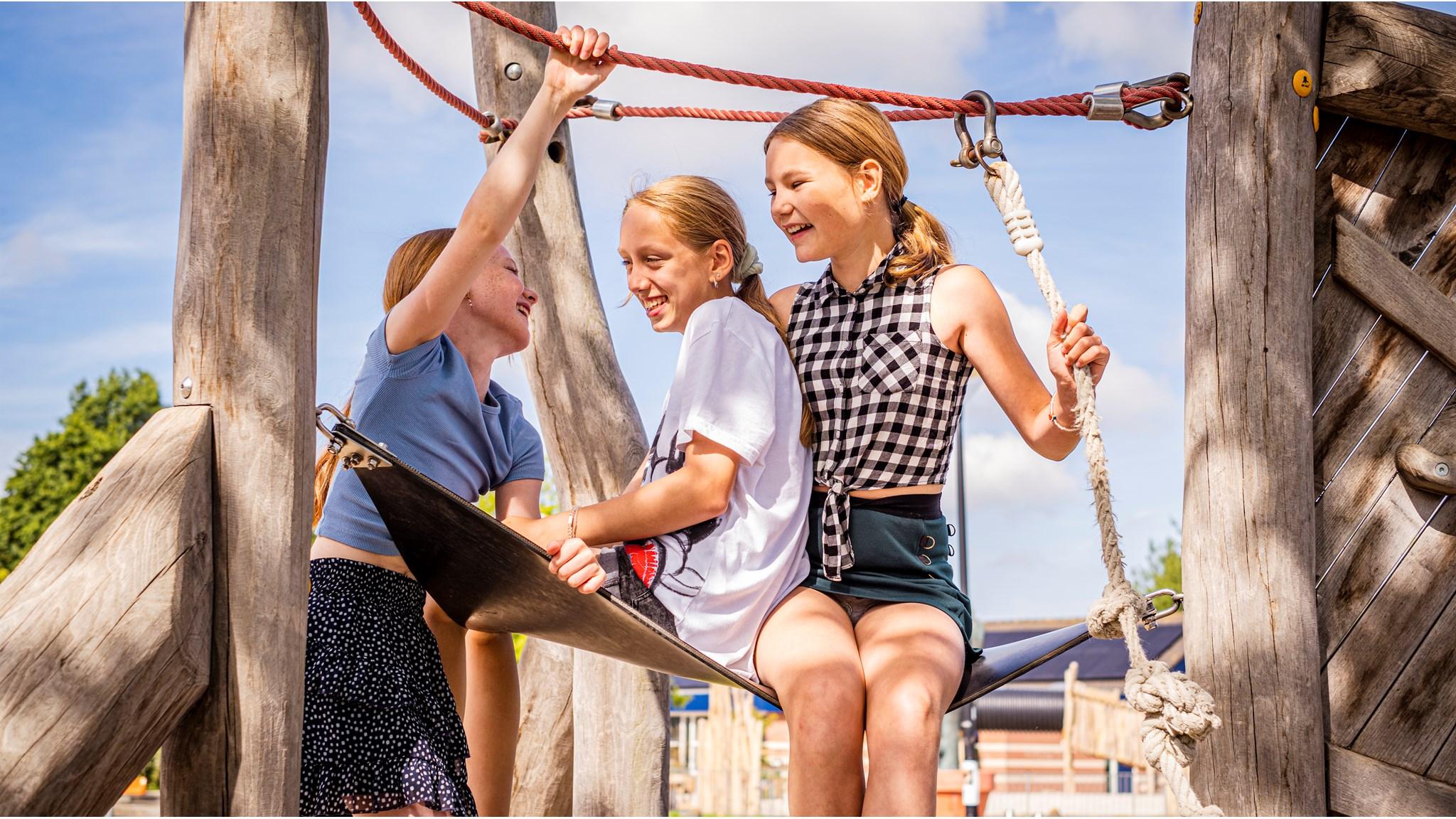 Drie lachende kinderen spelen samen op het schoolplein van Jenaplan Basisschool Vlinderbos in Wilnis. Drie lachende kinderen spelen samen op het schoolplein van Jenaplan Basisschool Vlinderbos in Wilnis.