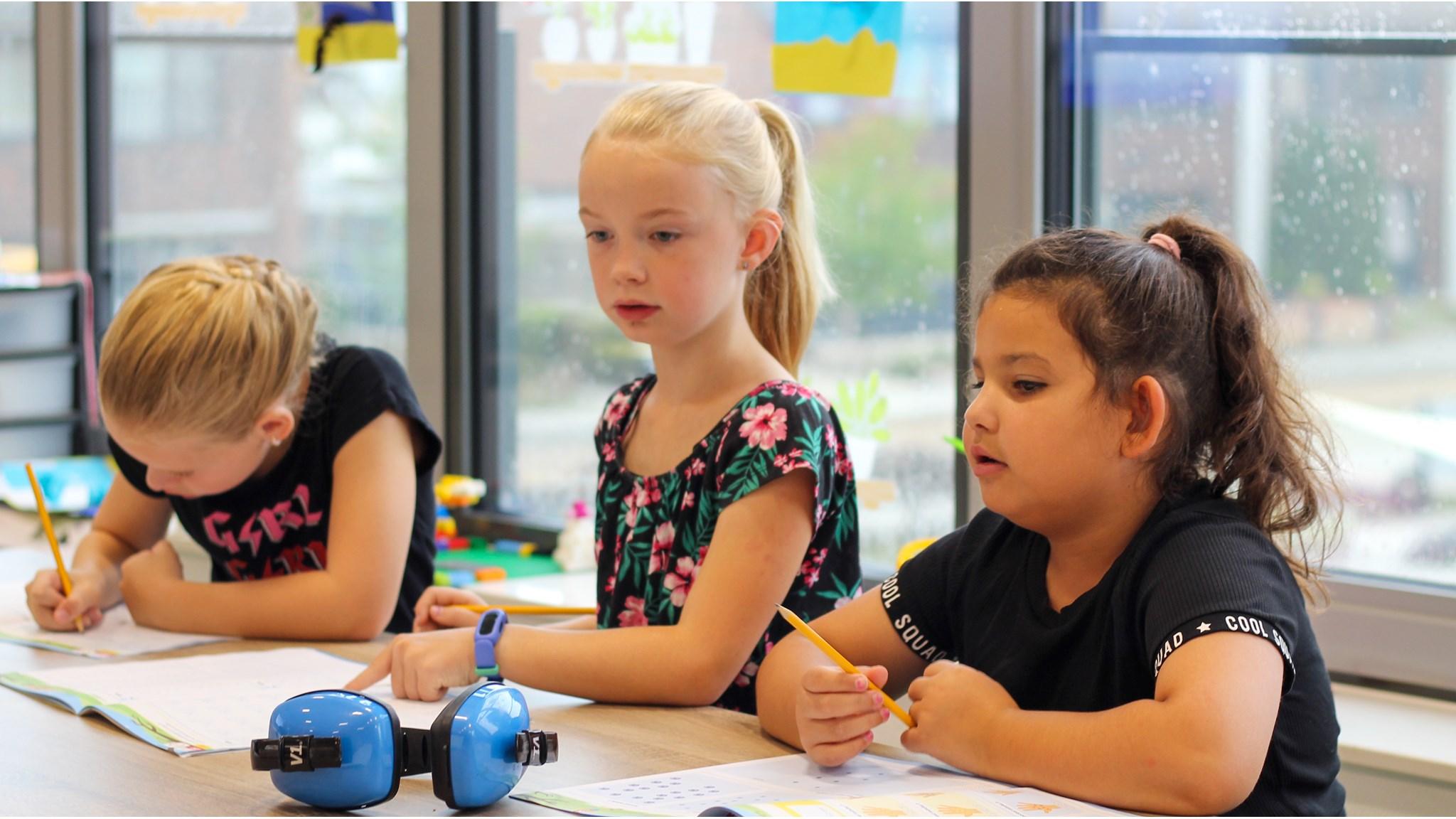 Drie leerlingen van Het Compas in Emmer-Compascuum zijn aan het werk in de klas. Drie leerlingen van Het Compas in Emmer-Compascuum zijn aan het werk in de klas.
