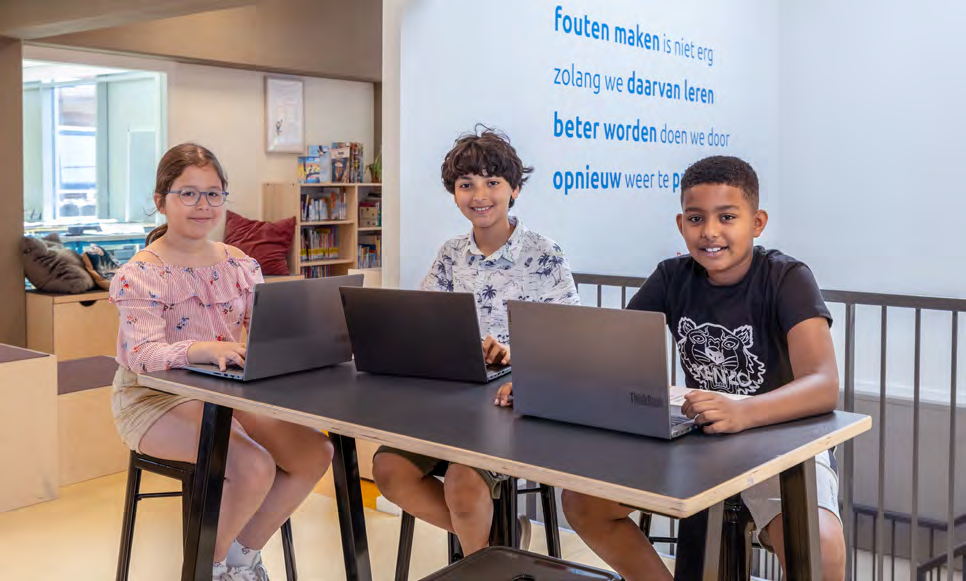 Drie leerlingen van KC Het Oude Westen in Rotterdam werken samen aan laptops in een moderne leeromgeving. Drie leerlingen van KC Het Oude Westen in Rotterdam werken samen aan laptops in een moderne leeromgeving.