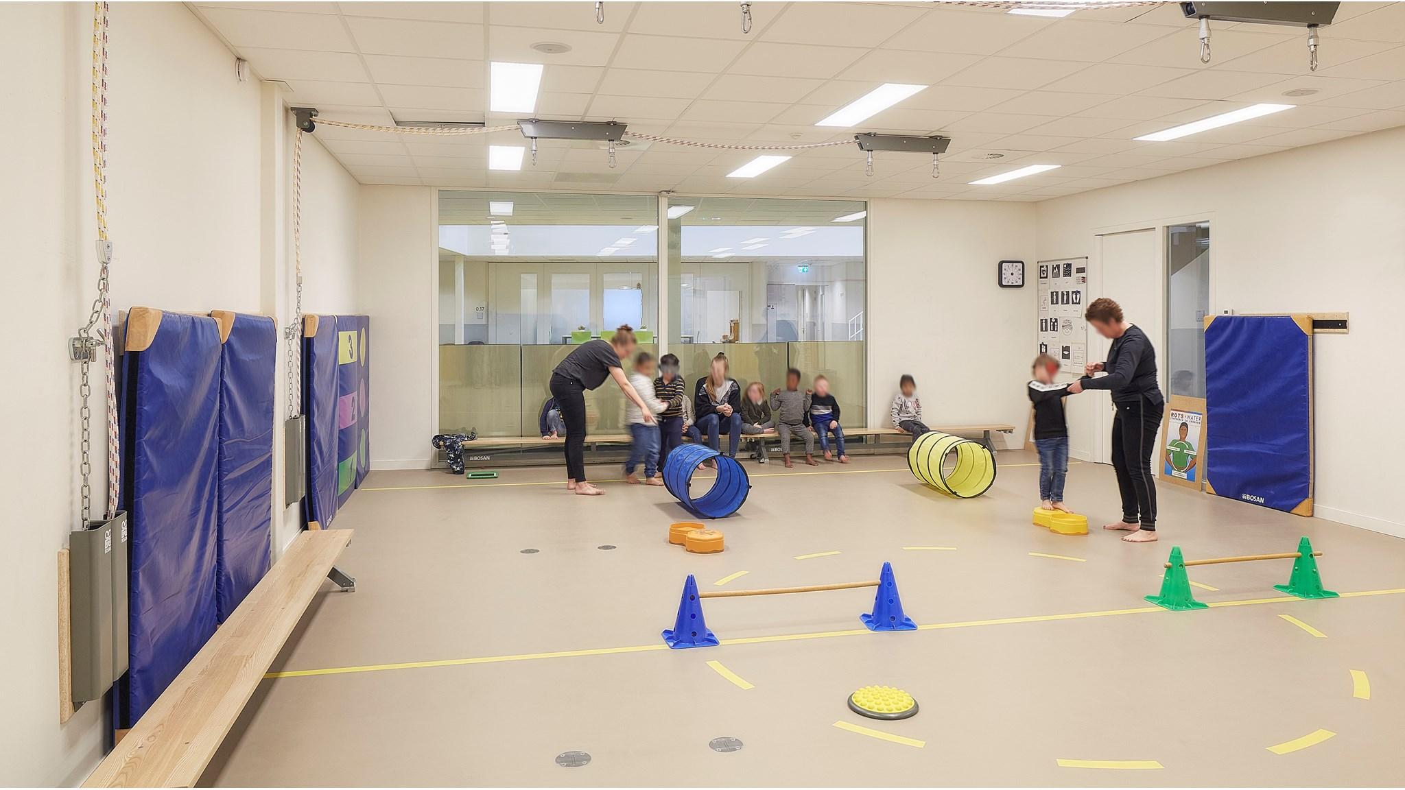 Een actieve les in de gymzaal van Basisschool De Regenboog in Hoensbroek met kinderen die aan een bewegingsactiviteit deelnemen. Een actieve les in de gymzaal van Basisschool De Regenboog in Hoensbroek met kinderen die aan een bewegingsactiviteit deelnemen.