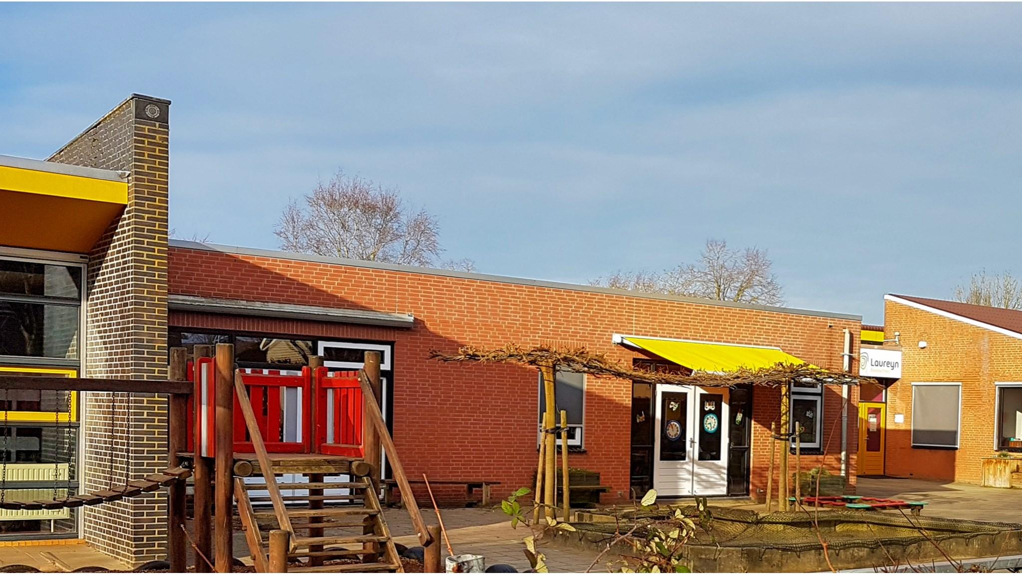 Een afbeelding van het schoolgebouw van Basisschool Laureyn in Philippine met een kleurrijk schoolplein. Een afbeelding van het schoolgebouw van Basisschool Laureyn in Philippine met een kleurrijk schoolplein.