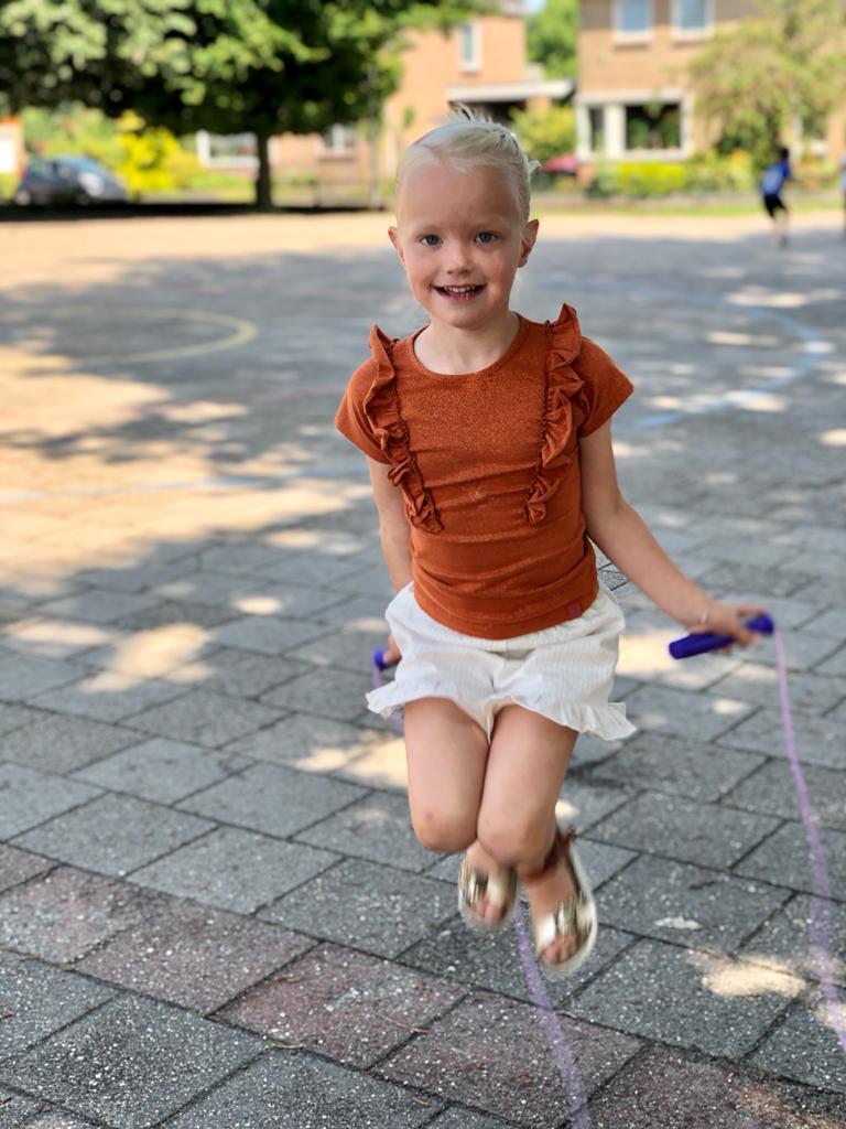 Een blij meisje springt touwtje op het schoolplein van De Wending in Roosendaal. Een blij meisje springt touwtje op het schoolplein van De Wending in Roosendaal.