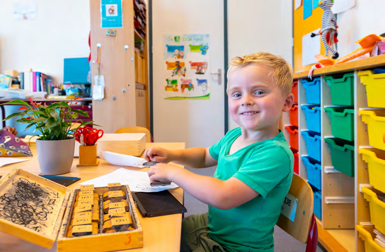 Een blije jongen aan het werk in de klas van de Prins Mauritsschool in Delft. Een blije jongen aan het werk in de klas van de Prins Mauritsschool in Delft.