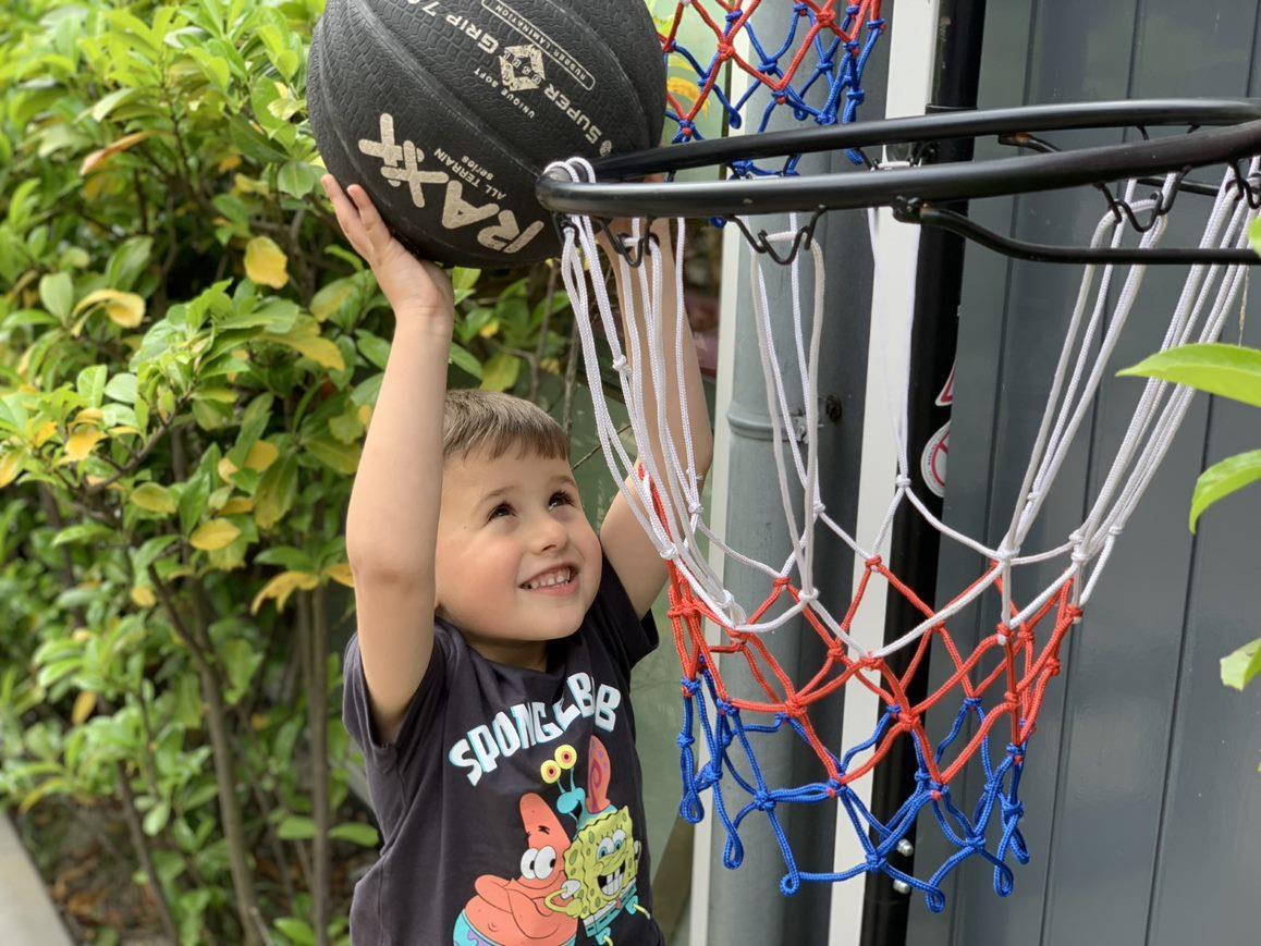 Een blije jongen gooit een basketbal in de ring op het schoolplein van de Prinses Marijkeschool in Den Haag. Een blije jongen gooit een basketbal in de ring op het schoolplein van de Prinses Marijkeschool in Den Haag.