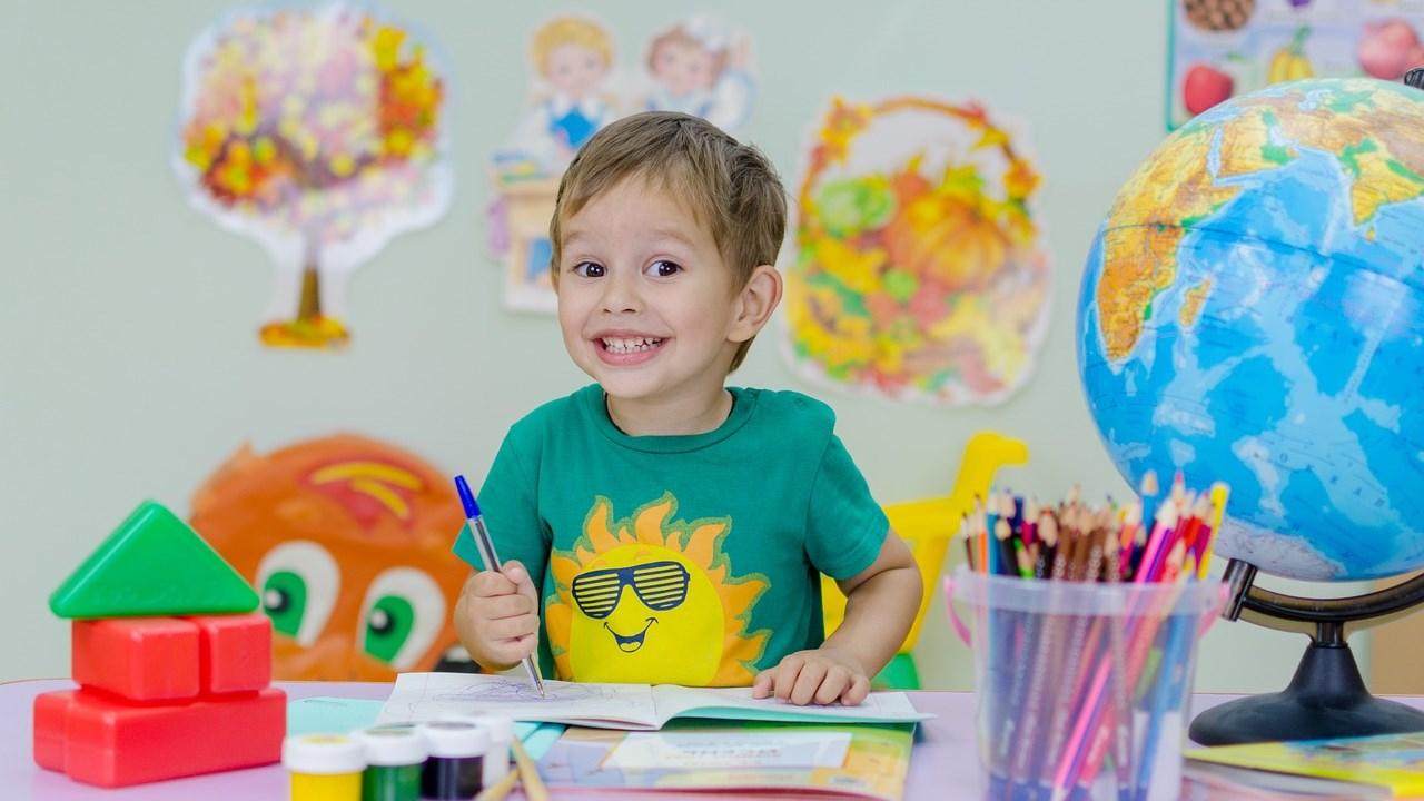 Een blije jongen met een zonnen T-shirt zit aan een tafel in de klas van OBS De Toonladder Zuilenstein in Nieuwegein. Een blije jongen met een zonnen T-shirt zit aan een tafel in de klas van OBS De Toonladder Zuilenstein in Nieuwegein.
