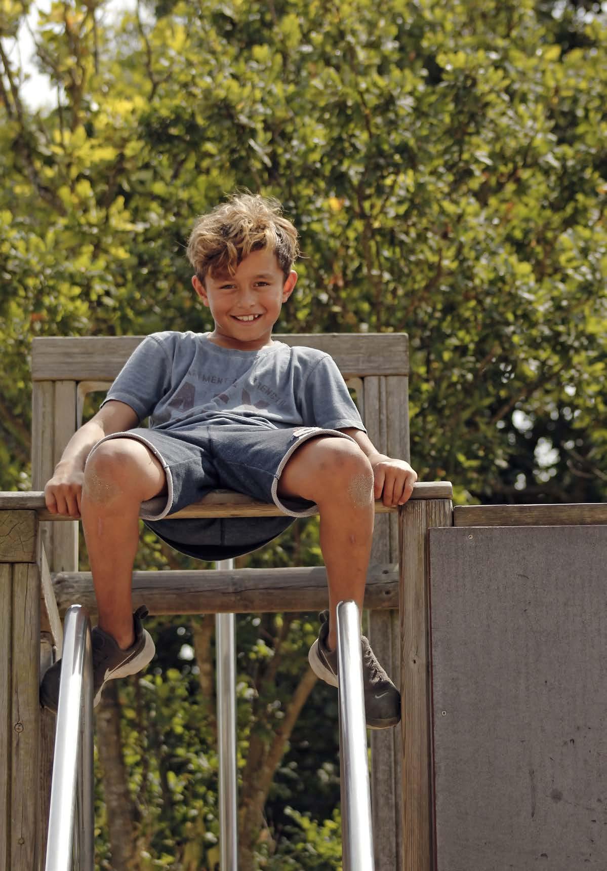 Een blije jongen speelt op de glijbaan op het schoolplein van Openbare basischool De Zeevonk in Zandvoort. Een blije jongen speelt op de glijbaan op het schoolplein van Openbare basischool De Zeevonk in Zandvoort.