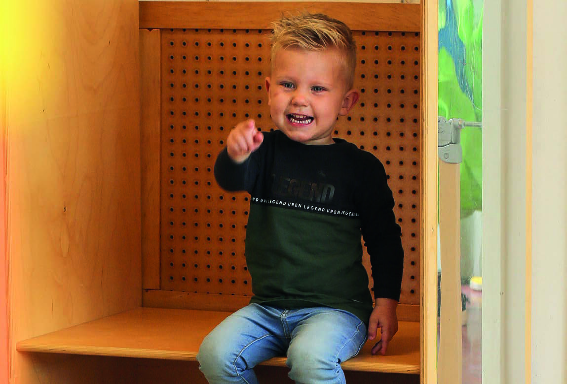 Een blije jongen zit op een bankje in Christelijk Kindcentrum De Wiedewereld in Sint Jansklooster. Een blije jongen zit op een bankje in Christelijk Kindcentrum De Wiedewereld in Sint Jansklooster.