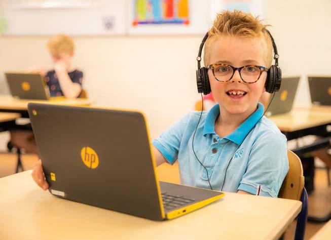 Een blije leerling met een laptop op PCBO De Wonderboom in Amersfoort.
