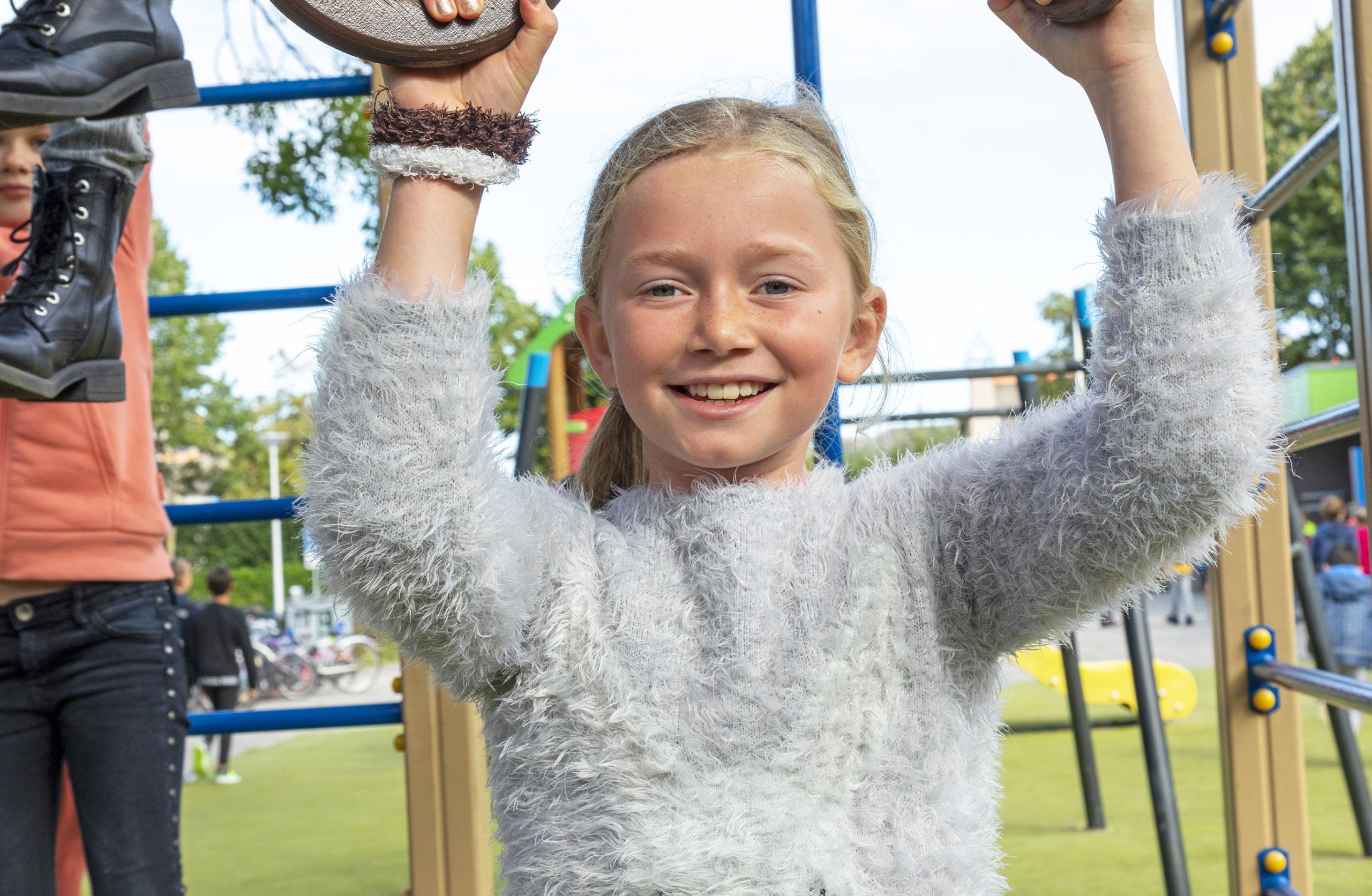Een blije leerling speelt op het schoolplein van De Brug in IJsselstein.
