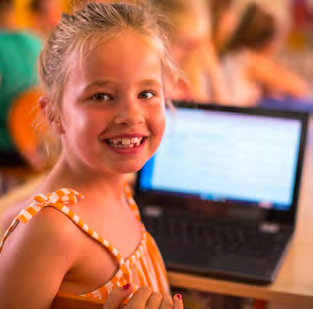 Een blije leerling van Basisschool Sint Jozef in Schipluiden die achter een laptop zit. Een blije leerling van Basisschool Sint Jozef in Schipluiden die achter een laptop zit.