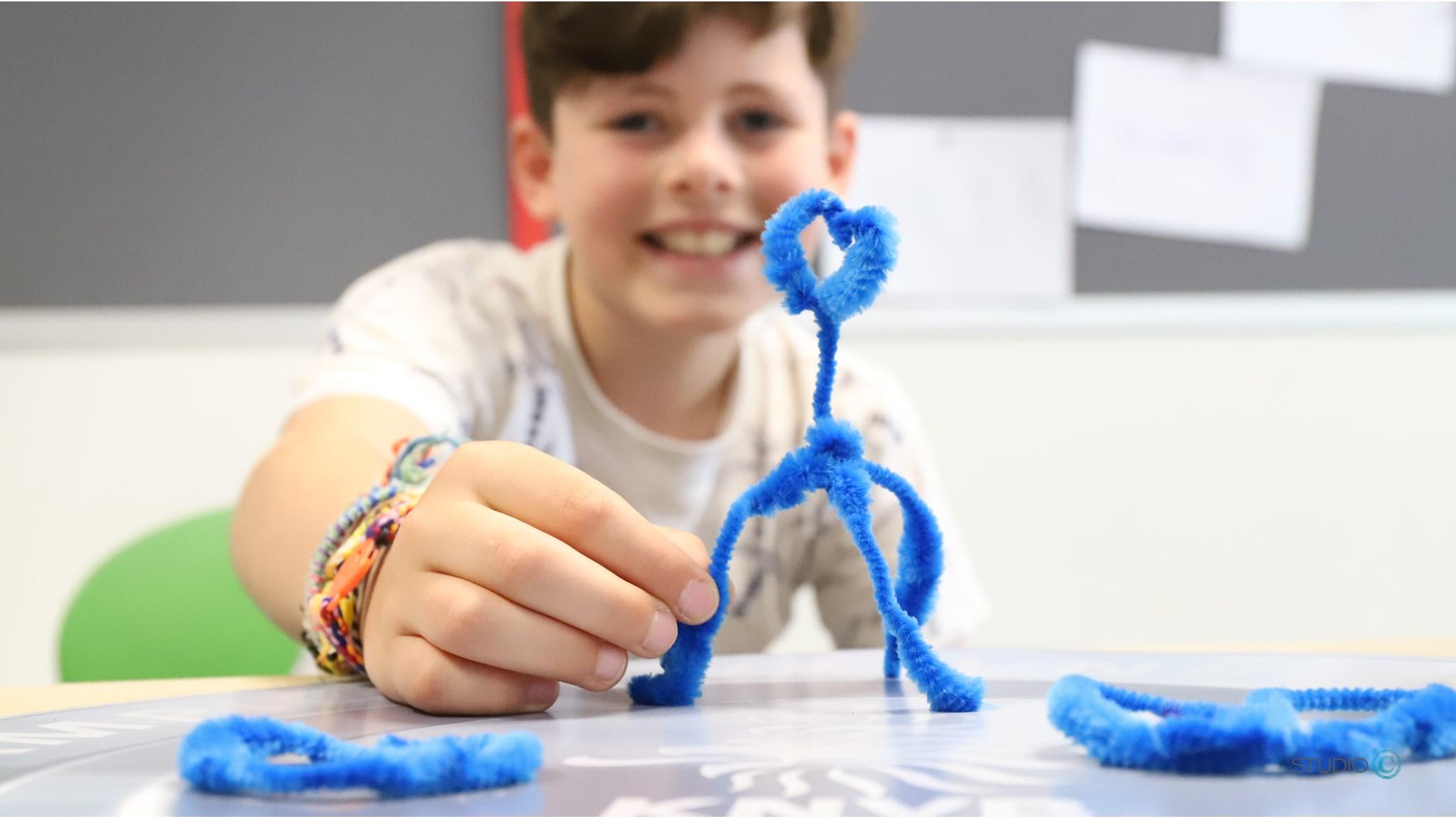 Een blije leerling van CBS De Enk in Eerbeek toont trots zijn creatie van blauwe pijpenragers. Een blije leerling van CBS De Enk in Eerbeek toont trots zijn creatie van blauwe pijpenragers.