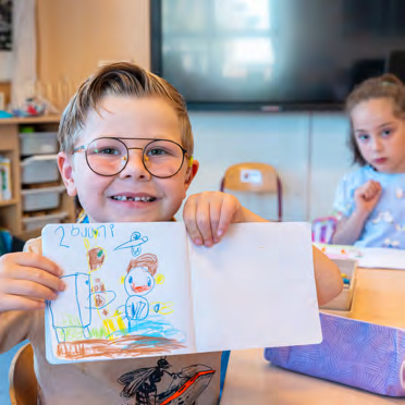 Een blije leerling van de Prins Mauritsschool in Delft toont zijn tekening in de klas. Een blije leerling van de Prins Mauritsschool in Delft toont zijn tekening in de klas.
