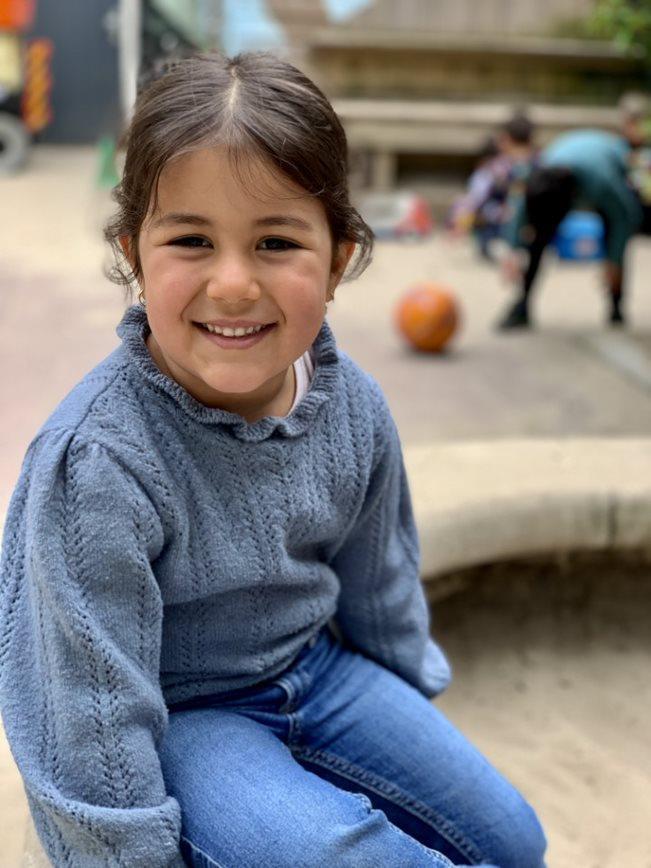 Een blije leerling van de Prinses Marijkeschool zit op het schoolplein in Den Haag. Een blije leerling van de Prinses Marijkeschool zit op het schoolplein in Den Haag.
