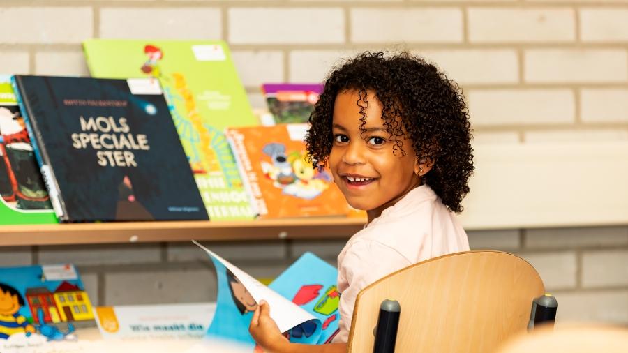 Een blije leerling van OBS De Akkers in Rotterdam geniet van een boek in de klas. Een blije leerling van OBS De Akkers in Rotterdam geniet van een boek in de klas.