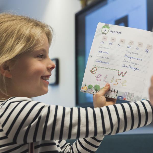Een blije leerling van Openbare Basisschool De Hasselbraam in Haaren toont haar werk. Een blije leerling van Openbare Basisschool De Hasselbraam in Haaren toont haar werk.