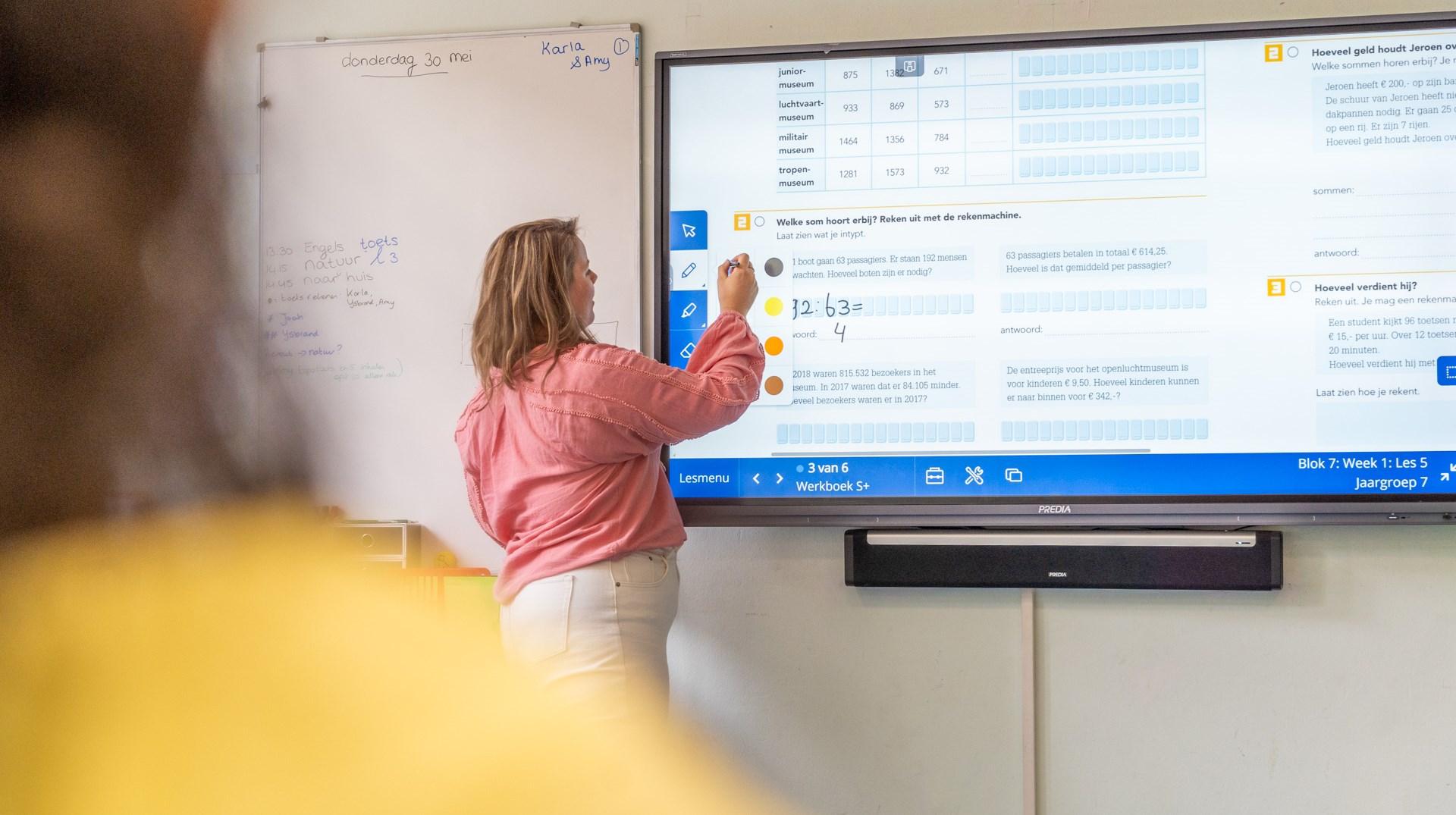 Een docent geeft les aan ABS Middelburg met behulp van een digitaal bord in een klaslokaal. Een docent geeft les aan ABS Middelburg met behulp van een digitaal bord in een klaslokaal.