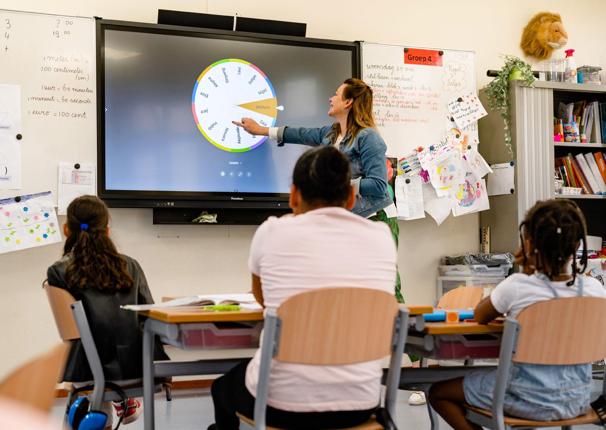 Een docente geeft instructies aan leerlingen in de klas van Het Stroomdal in Zwolle, met een interactief bord. Een docente geeft instructies aan leerlingen in de klas van Het Stroomdal in Zwolle, met een interactief bord.