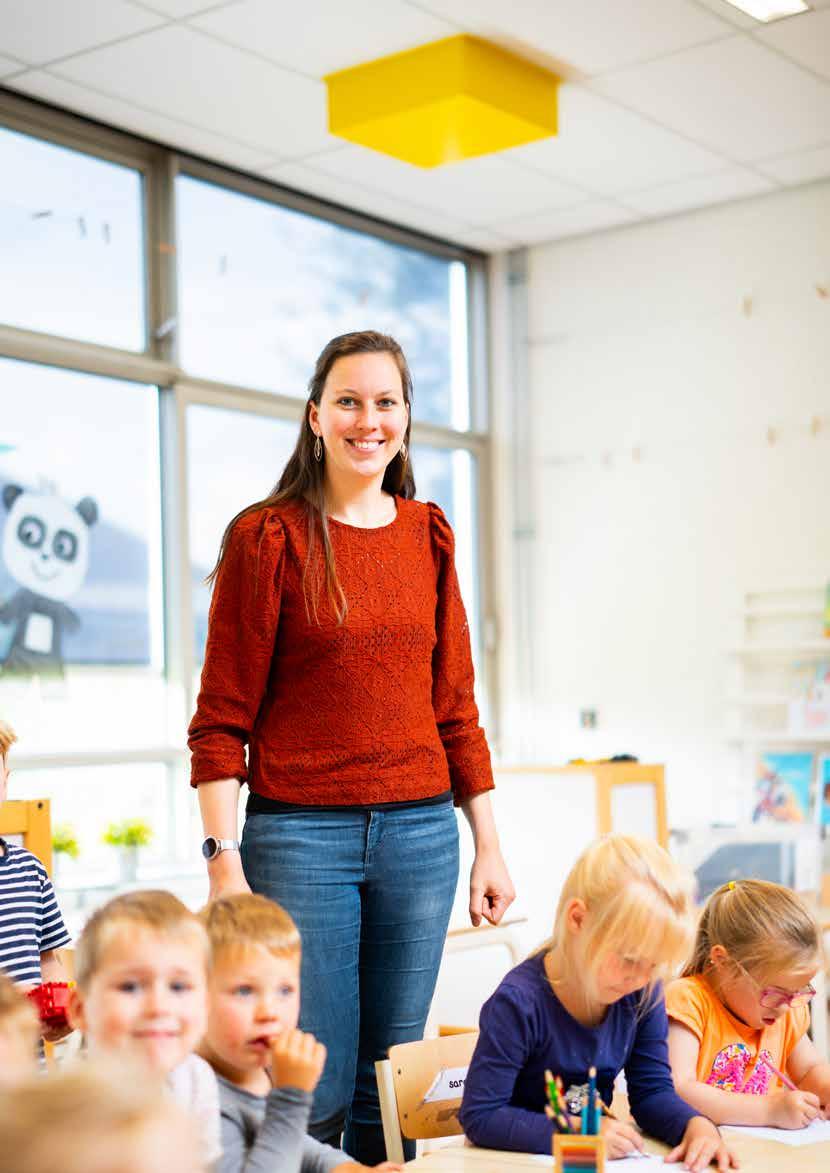 Een docente staat lachend voor de klas aan de Van Lingenschool in Zetten. Een docente staat lachend voor de klas aan de Van Lingenschool in Zetten.