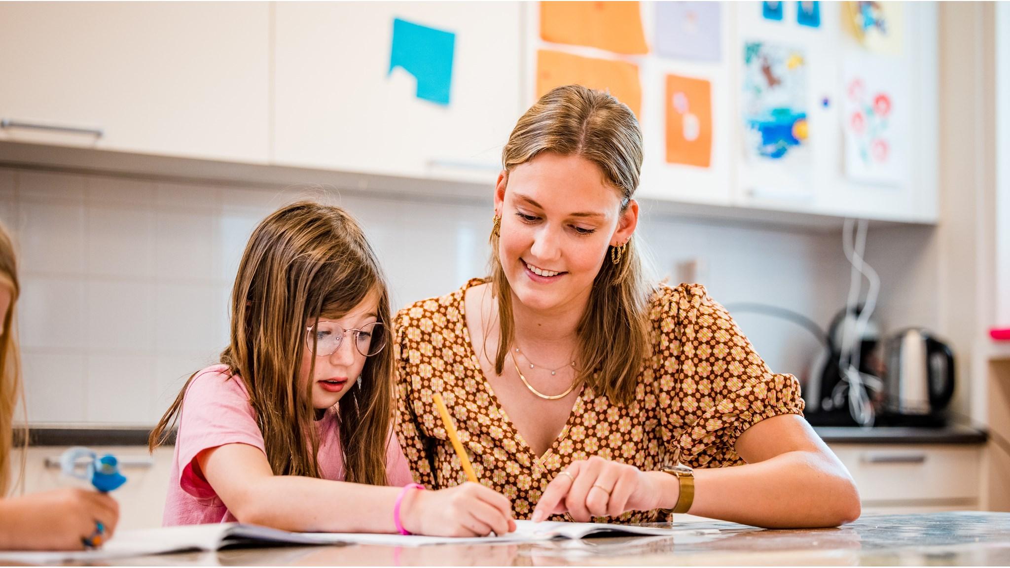 Een docente van De Wheemschool in Voorthuizen helpt een leerling met haar huiswerk. Een docente van De Wheemschool in Voorthuizen helpt een leerling met haar huiswerk.