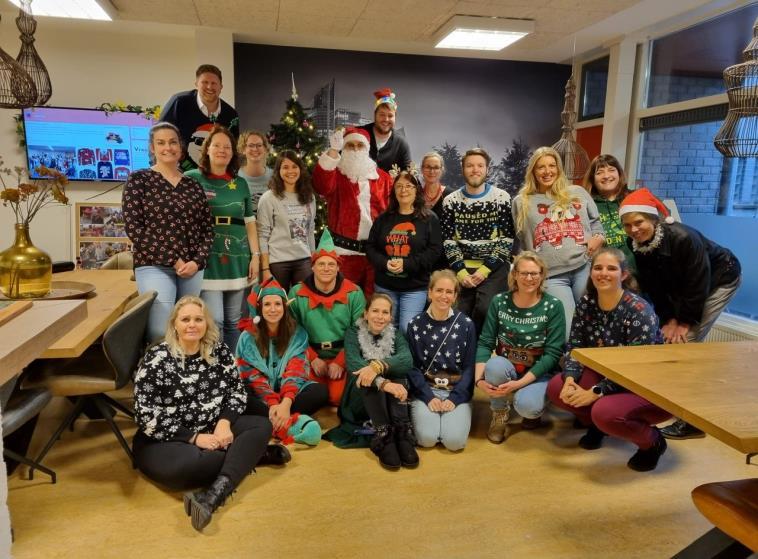 Een feestelijke bijeenkomst van het personeel van De Triangel in Den Haag, met kerstkostuums en een kerstboom op de achtergrond. Een feestelijke bijeenkomst van het personeel van De Triangel in Den Haag, met kerstkostuums en een kerstboom op de achtergrond.