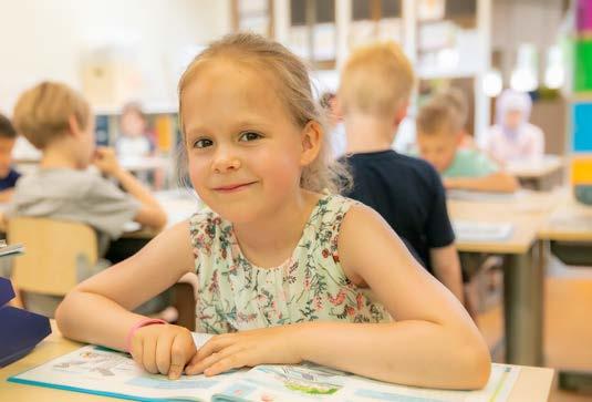 Een glimlachend meisje in de klas van PCBO De Wonderboom in Amersfoort.
