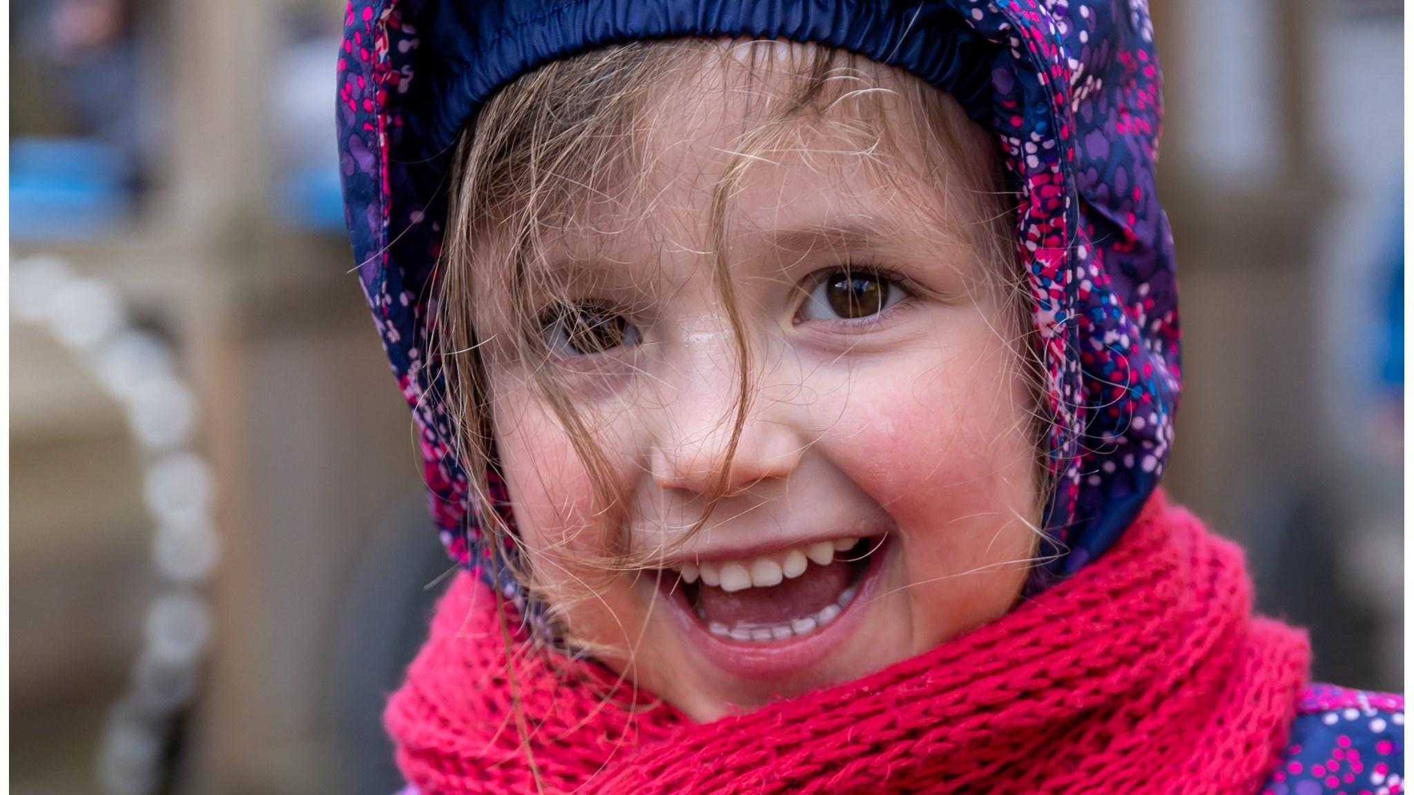 Een glimlachend meisje in een winterse outfit op het schoolplein van IKC De Hunenborg in Hengelo. Een glimlachend meisje in een winterse outfit op het schoolplein van IKC De Hunenborg in Hengelo.