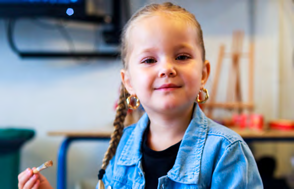 Een glimlachend meisje met een snack in een klaslokaal van basisschool Paulus in Enschede. Een glimlachend meisje met een snack in een klaslokaal van basisschool Paulus in Enschede.