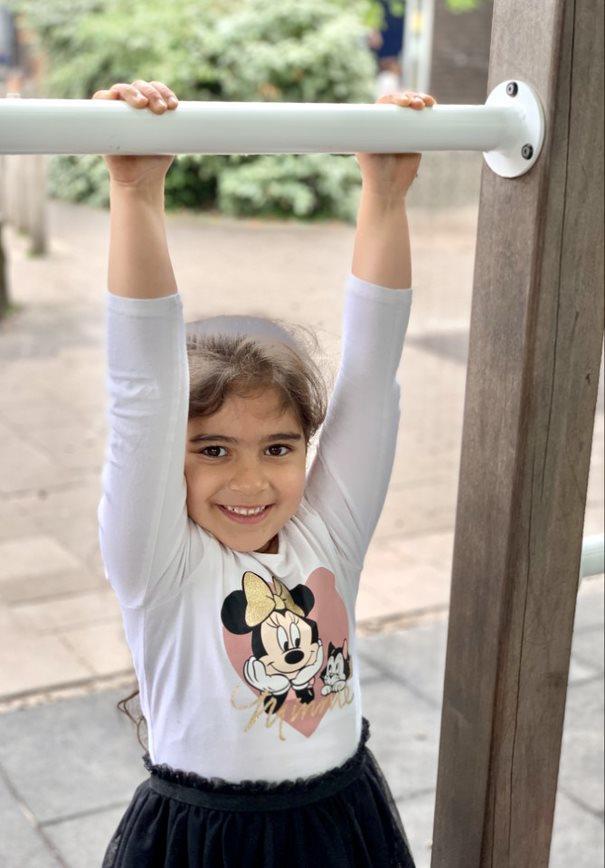Een glimlachend meisje speelt op de speelgoedtoestellen op het schoolplein van de Prinses Marijkeschool in Den Haag. Een glimlachend meisje speelt op de speelgoedtoestellen op het schoolplein van de Prinses Marijkeschool in Den Haag.