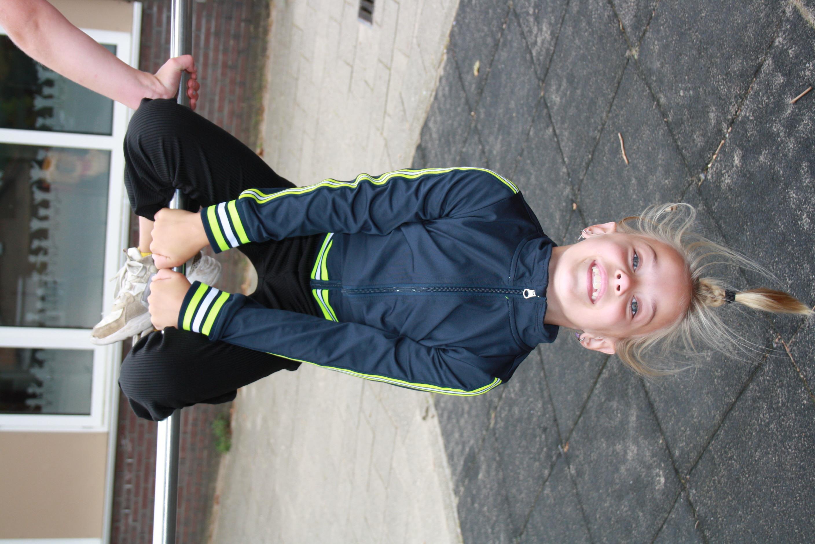 Een glimlachend meisje speelt op het schoolplein van Basisschool Jan Ligthart in Zelhem.