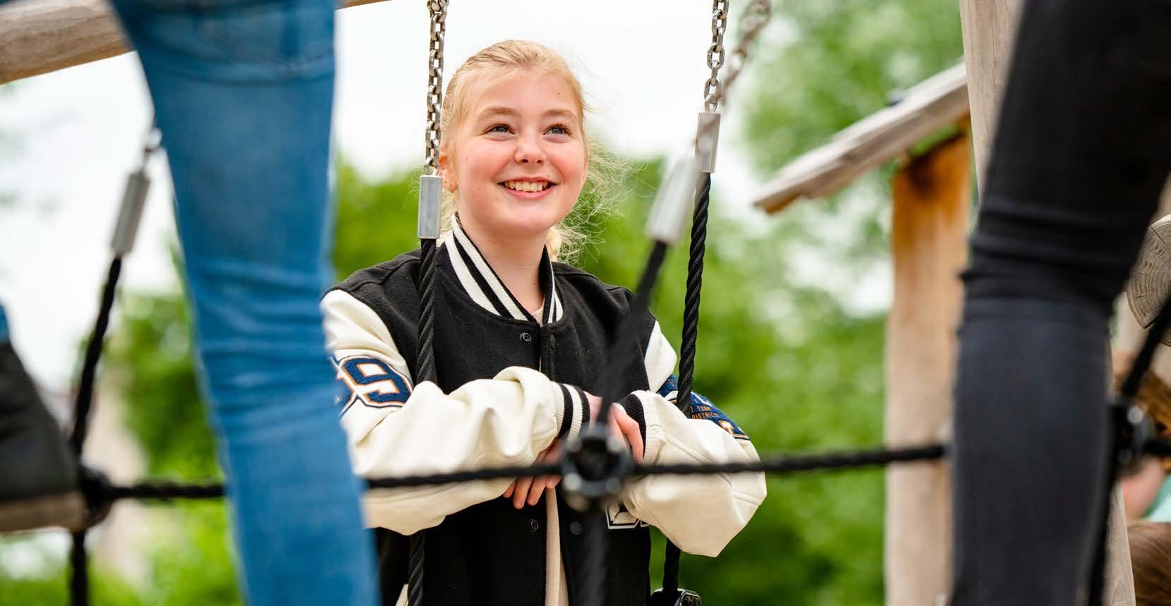 Een glimlachend meisje speelt op het schoolplein van De Ichthus in Zwolle. Een glimlachend meisje speelt op het schoolplein van De Ichthus in Zwolle.