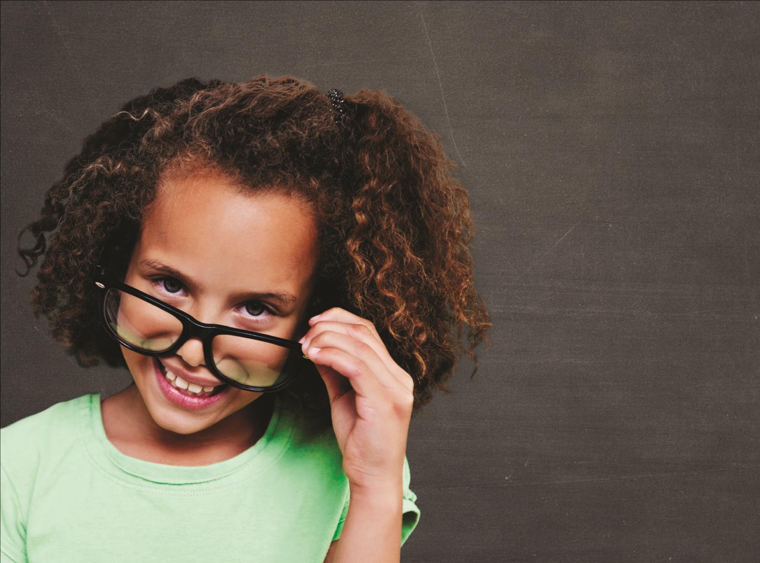 Een glimlachende leerling met een groene T-shirt en een bril, Basisschool Mikado in Hengelo. Een glimlachende leerling met een groene T-shirt en een bril, Basisschool Mikado in Hengelo.