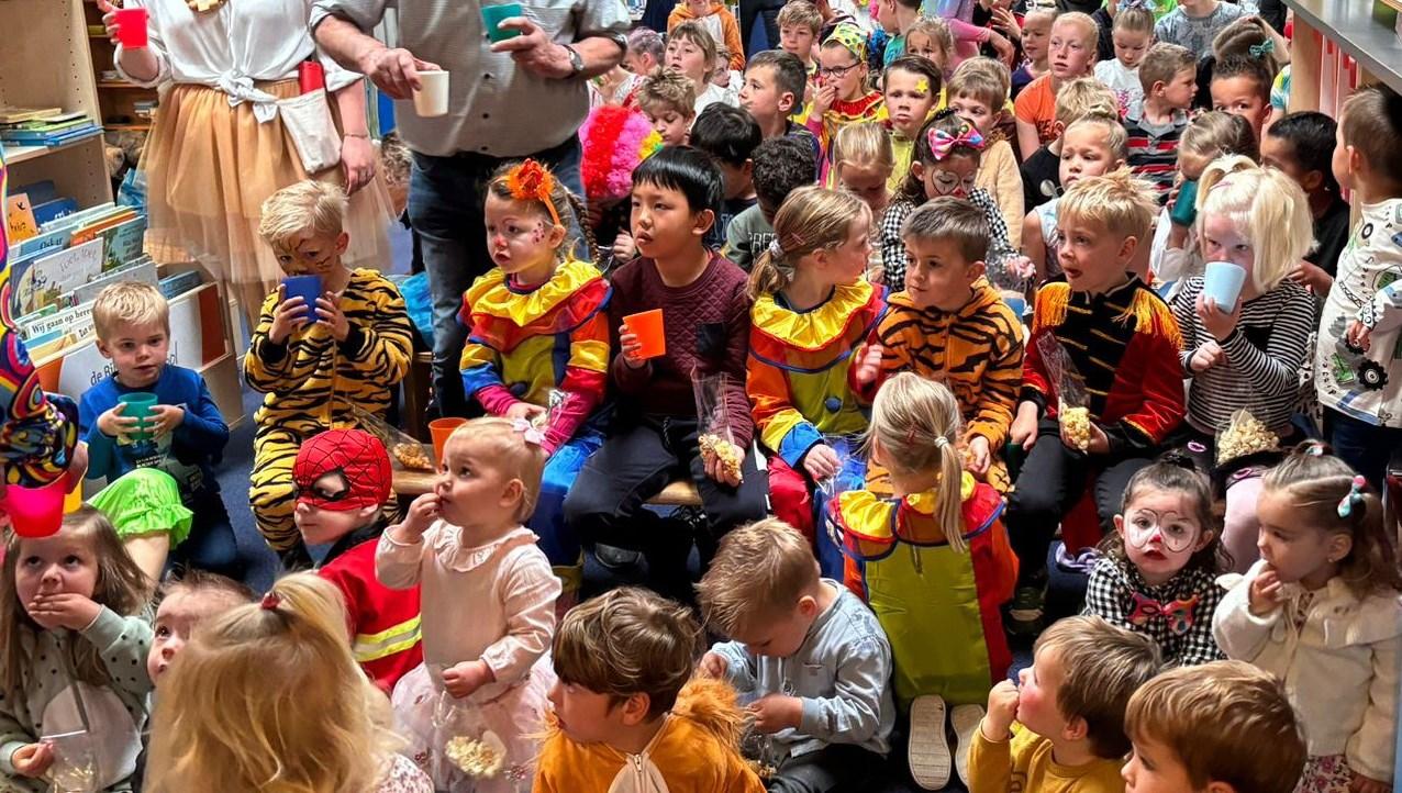 Een groep blije kinderen in kleurige kostuums geniet van een activiteit op Kindcentrum De Morgenster in Kerkwerve.