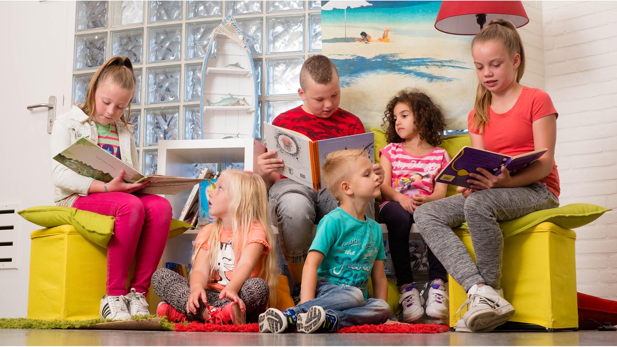 Een groep kinderen leest boeken in een gezellige ruimte van school De Kubus in Enschede. Een groep kinderen leest boeken in een gezellige ruimte van school De Kubus in Enschede.