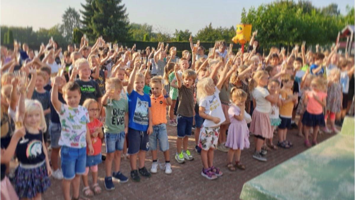 Een groep kinderen viert op het schoolplein van Basisschool De Kwir in Neer. Een groep kinderen viert op het schoolplein van Basisschool De Kwir in Neer.