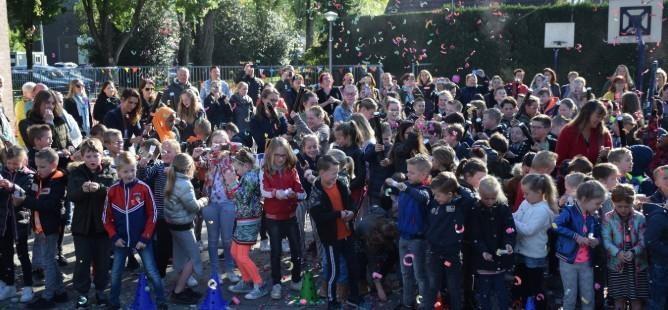 Een grote groep leerlingen en ouders viert een activiteit op het schoolplein van Basisschool Beisterveld in Bergeijk. Een grote groep leerlingen en ouders viert een activiteit op het schoolplein van Basisschool Beisterveld in Bergeijk.