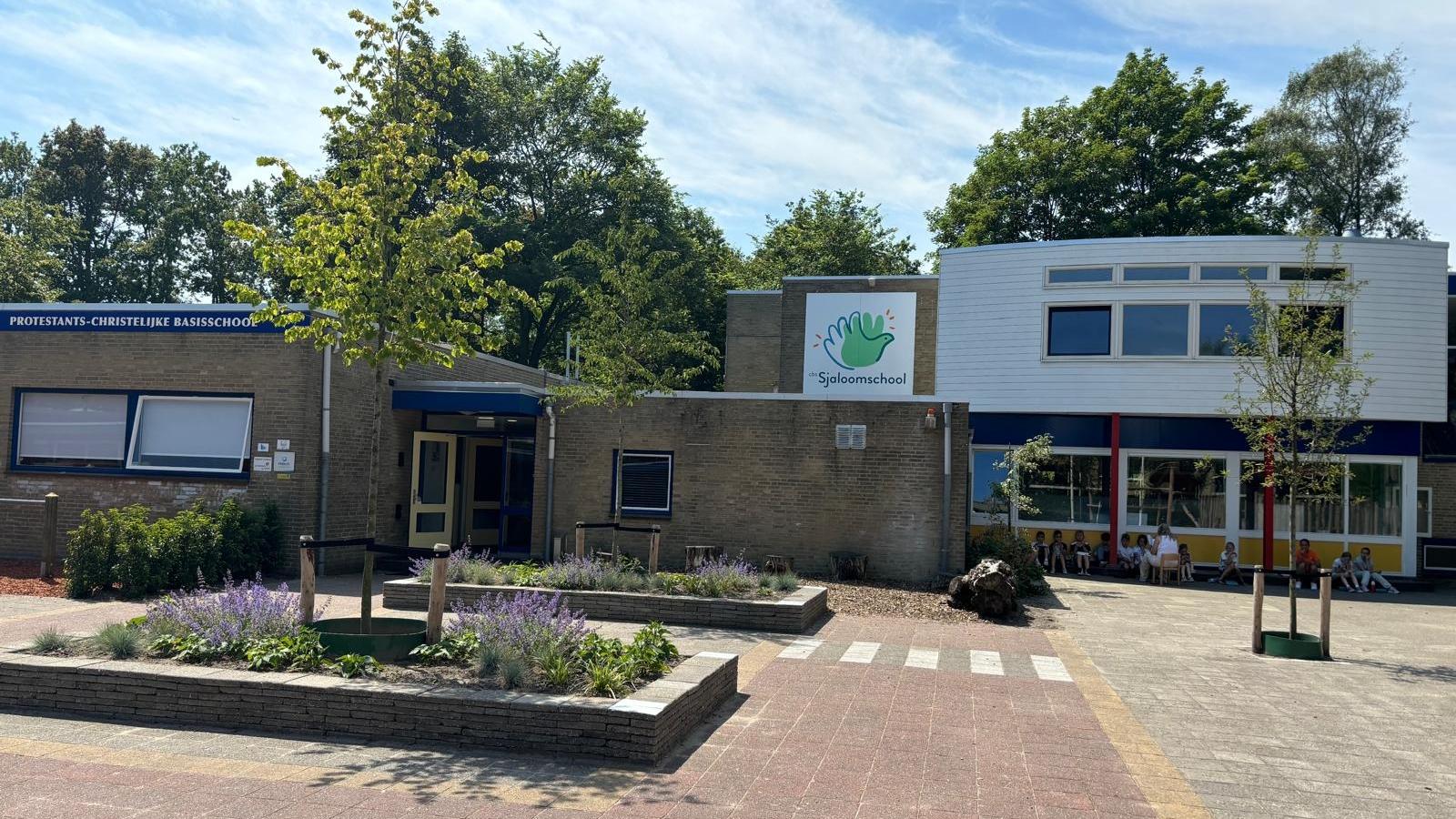 Een helderbeeld van de Sjaloomschool in Katwijk (Zuid-Holland) met een groene omgeving en vrolijke kinderen op het schoolplein. Een helderbeeld van de Sjaloomschool in Katwijk (Zuid-Holland) met een groene omgeving en vrolijke kinderen op het schoolplein.