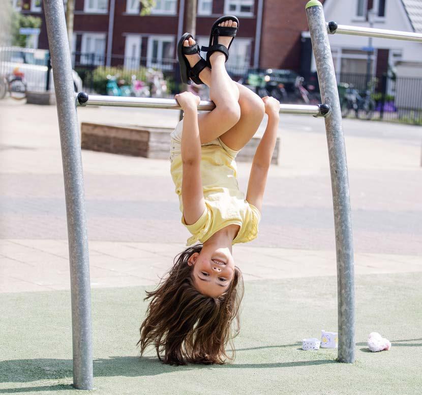Een jong meisje hangt ondersteboven aan een rek op het schoolplein van Christelijke Basisschool in Oost-Souburg. Een jong meisje hangt ondersteboven aan een rek op het schoolplein van Christelijke Basisschool in Oost-Souburg.