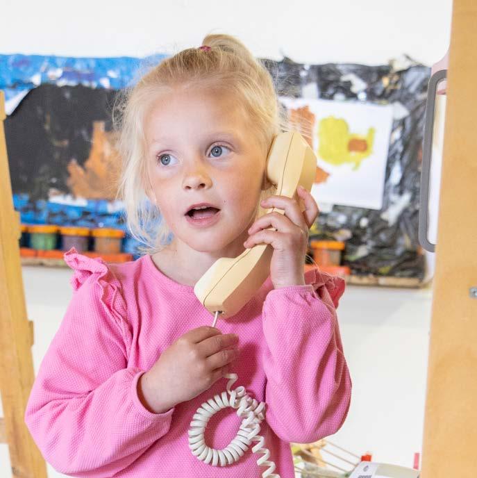 Een jong meisje in een roze trui die met een ouderwetse telefoon spreekt op basisschool Palmenhof in Middelburg. Een jong meisje in een roze trui die met een ouderwetse telefoon spreekt op basisschool Palmenhof in Middelburg.