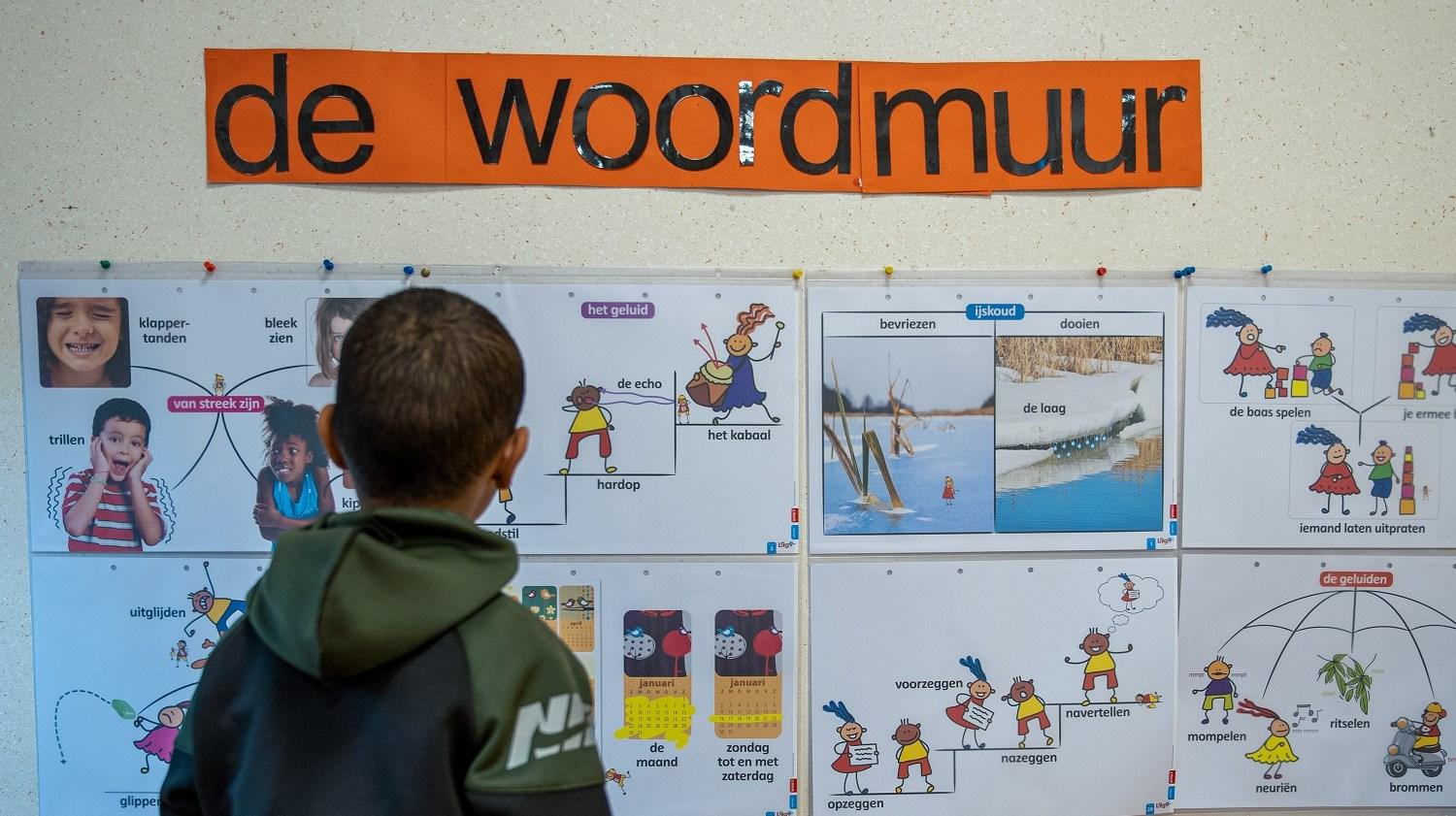 Een jongen bekijkt de woordmuur in basisschool Ikra in Dordrecht.