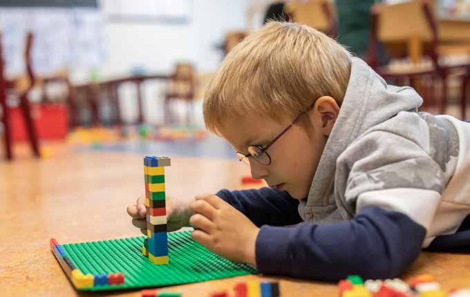 Een jongen bouwt geconcentreerd met blokken op het schoolplein van De Achtbaan in Tiel. Een jongen bouwt geconcentreerd met blokken op het schoolplein van De Achtbaan in Tiel.
