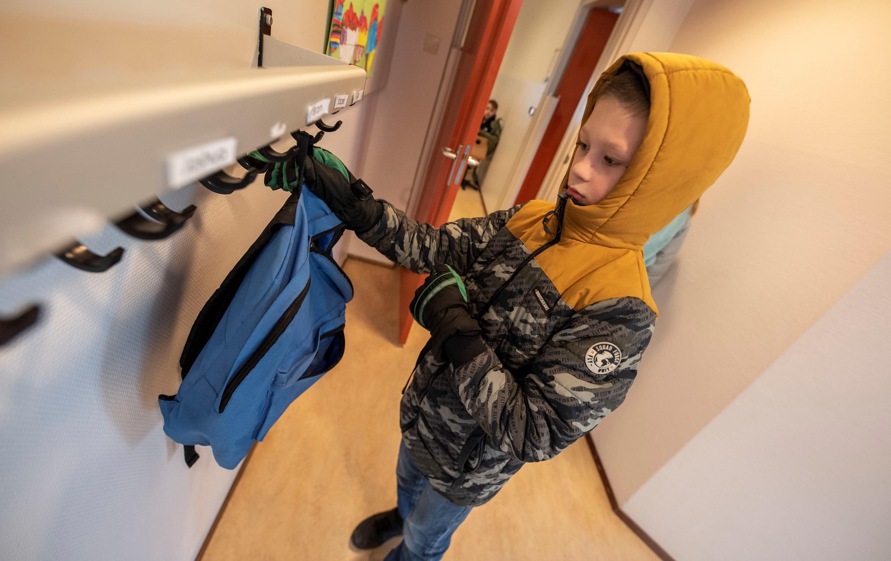 Een jongen hangt zijn blauwe tas op in de gang van basisschool Het Mozaïek in Almelo. Een jongen hangt zijn blauwe tas op in de gang van basisschool Het Mozaïek in Almelo.