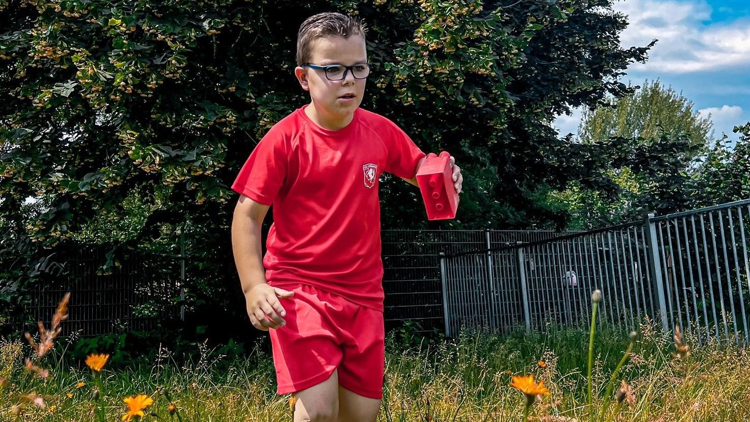 Een jongen in een rood sportoutfit speelt op het schoolplein van Christelijke Basisschool De Veenbrug in Daarlerveen. Een jongen in een rood sportoutfit speelt op het schoolplein van Christelijke Basisschool De Veenbrug in Daarlerveen.