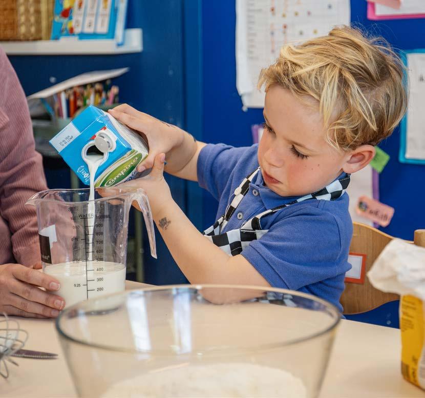 Een jongen in een schort giet melk in een maatbeker tijdens een les op de Christelijke Basisschool in Oost-Souburg. Een jongen in een schort giet melk in een maatbeker tijdens een les op de Christelijke Basisschool in Oost-Souburg.