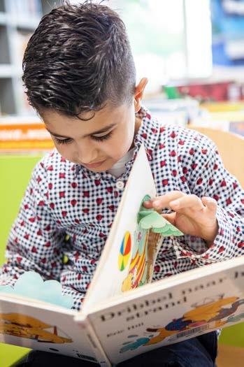 Een jongen leest een boek in de bibliotheek van Basisschool Lambertus in Swalmen. Een jongen leest een boek in de bibliotheek van Basisschool Lambertus in Swalmen.