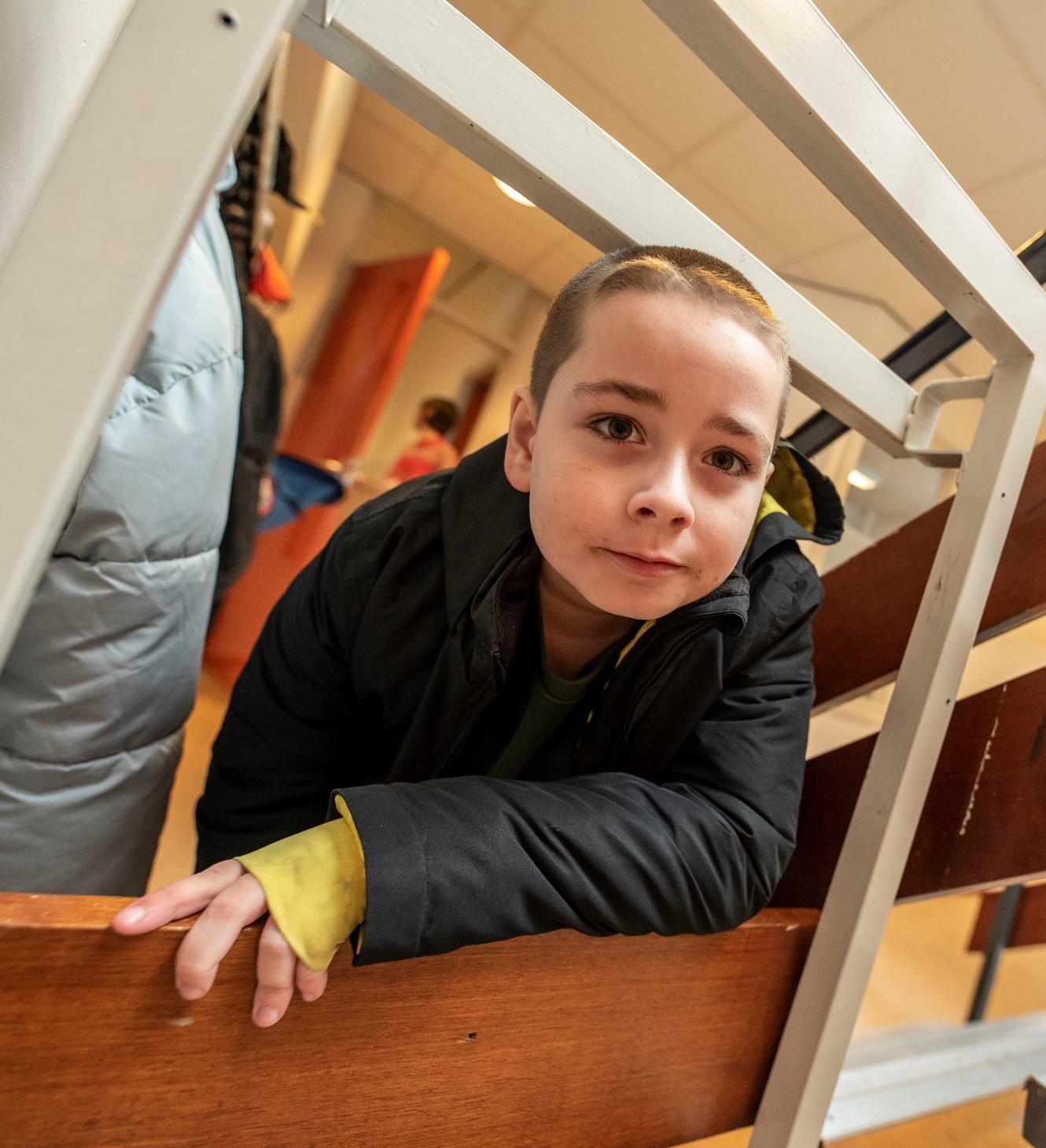 Een jongen leunt over een houten leuning in 'Het Mozaïek' school in Almelo. Een jongen leunt over een houten leuning in 'Het Mozaïek' school in Almelo.